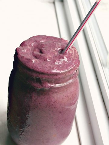 a purple kiwi and blueberry smoothie with a straw